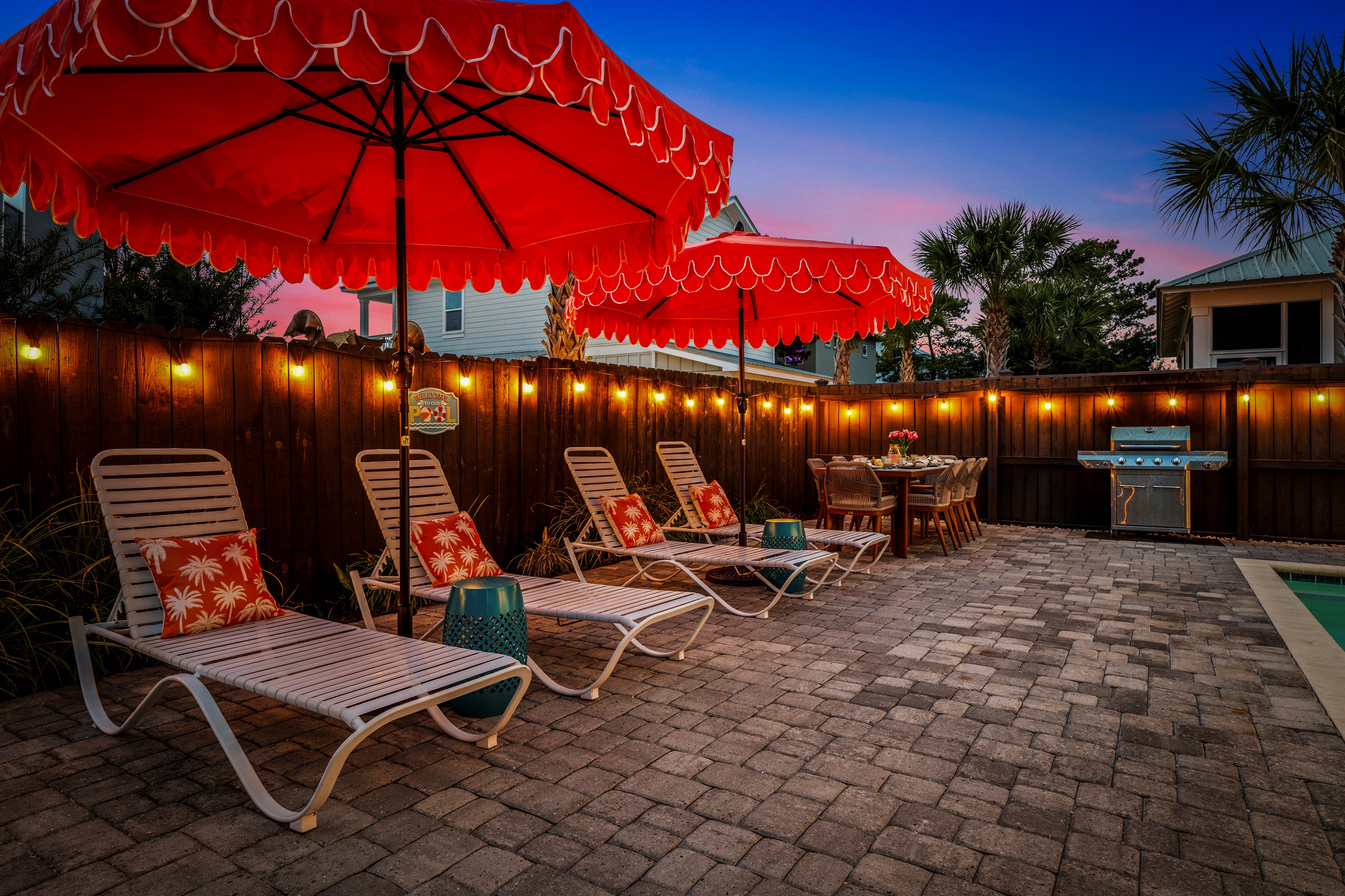 Sunshine, loungers, and bright red umbrellas create the perfect poolside escape after a day at Miramar Beach.