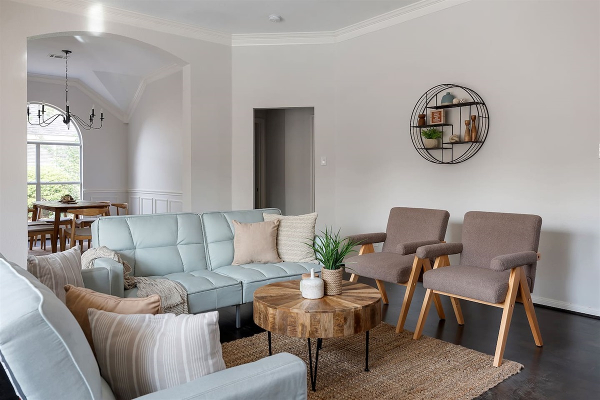 Welcome to our inviting living space with cozy sofas and a sleek TV setup. Shaded windows bring in just the right amount of natural light, creating a perfect balance of comfort and ambiance.