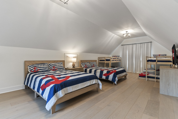 Bunk room has 2 queen size beds and 2 bunk beds with twin mattress on top and double mattress on the bottom. Dresser and TV and night lights.