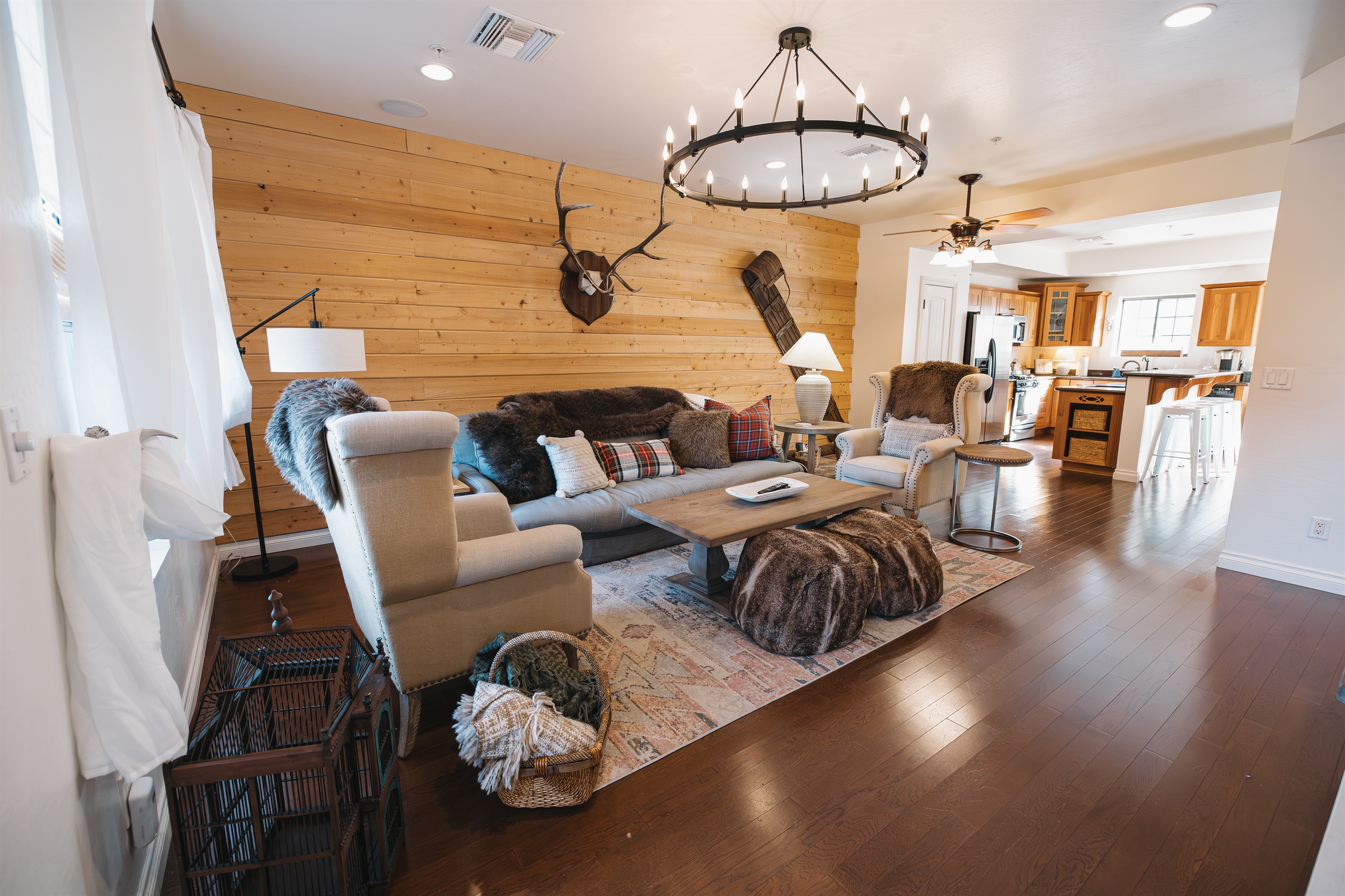 Spacious mountain-lodge living room with wood accent wall, plush seating, cozy lighting, and open-concept flow—perfect for gathering with family, relaxing after outdoor adventures, or unwinding by night.