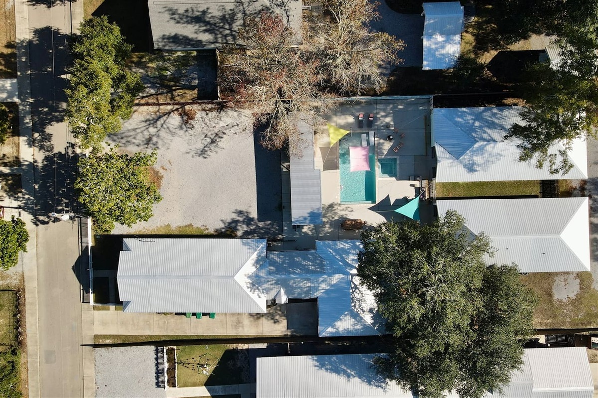 Top-down aerial view highlighting the pool courtyard surrounded by charming cottages.