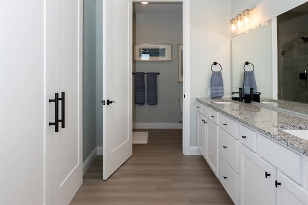 Primary Bathroom ensuite with double basin sinks and large closet.