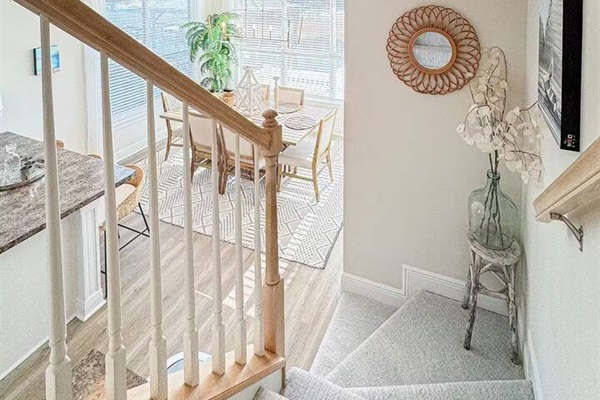 Airy stairway with natural light and stylish decor, offering a warm welcome and easy flow between levels.