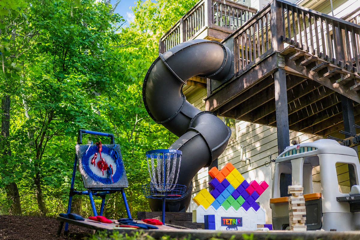 This is where downtime turns into memory-making: kids playing, adults laughing, and everyone drifting between games, the slide, and the mountain air.