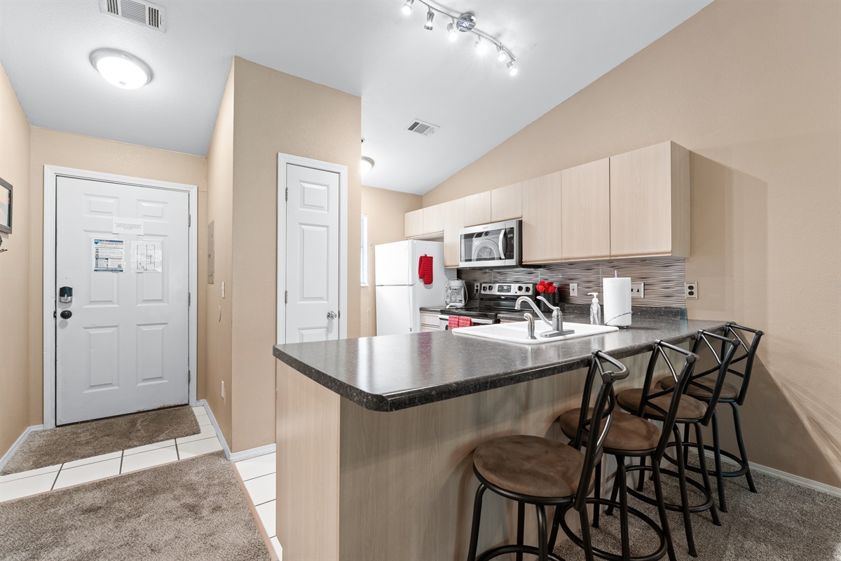 The entry opens into a bright, easy layout with bar seating ready for a quick breakfast or evening drink.