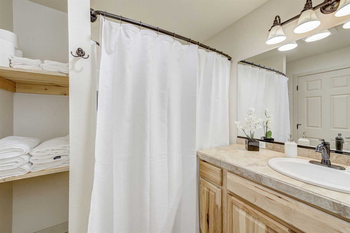 Bathroom with bathtub and plenty of towels.