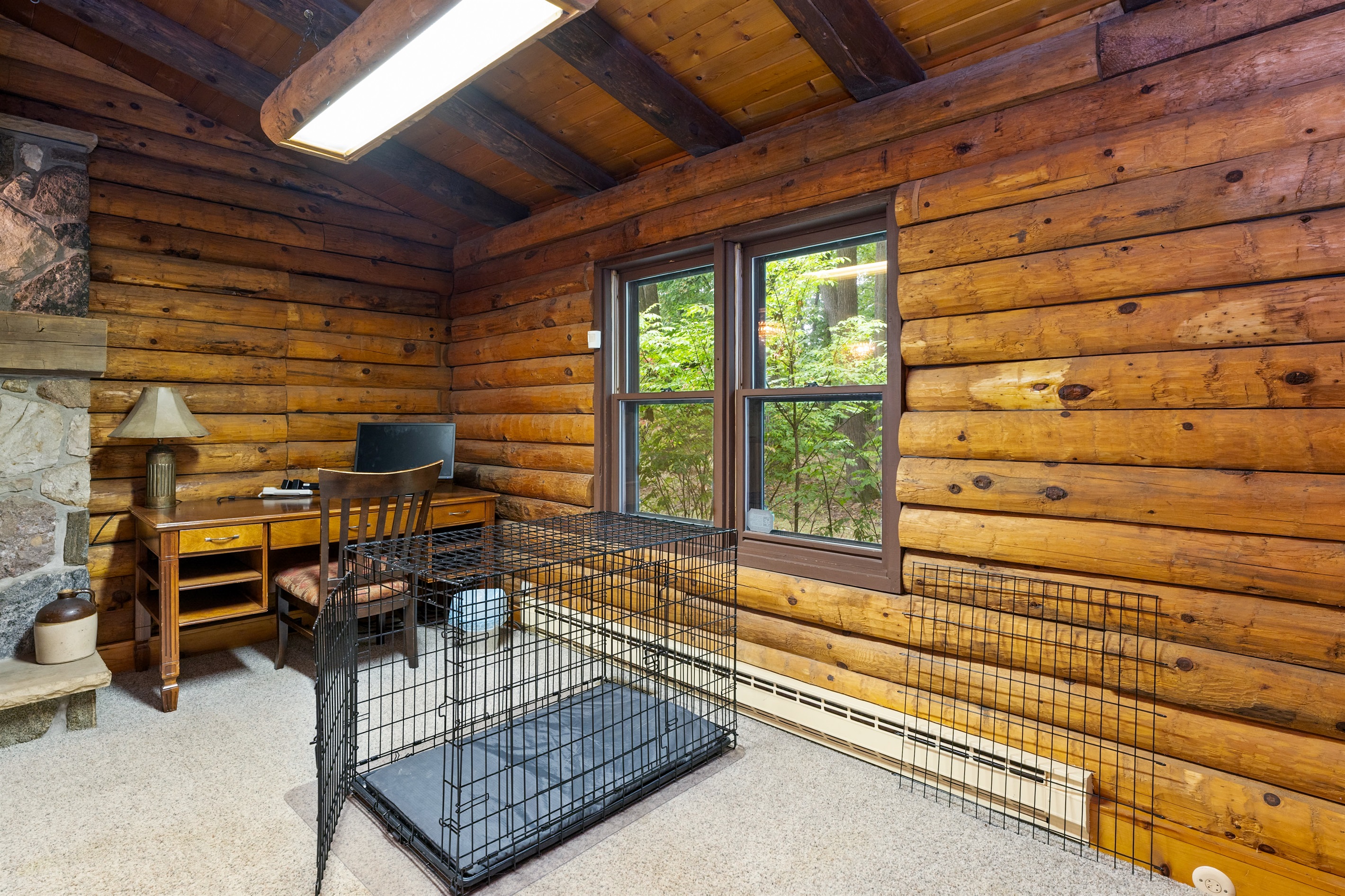 Rustic charm meets function in this cozy log cabin office—perfect for working remotely while enjoying woodland views. Dog crate available for your furry friend.