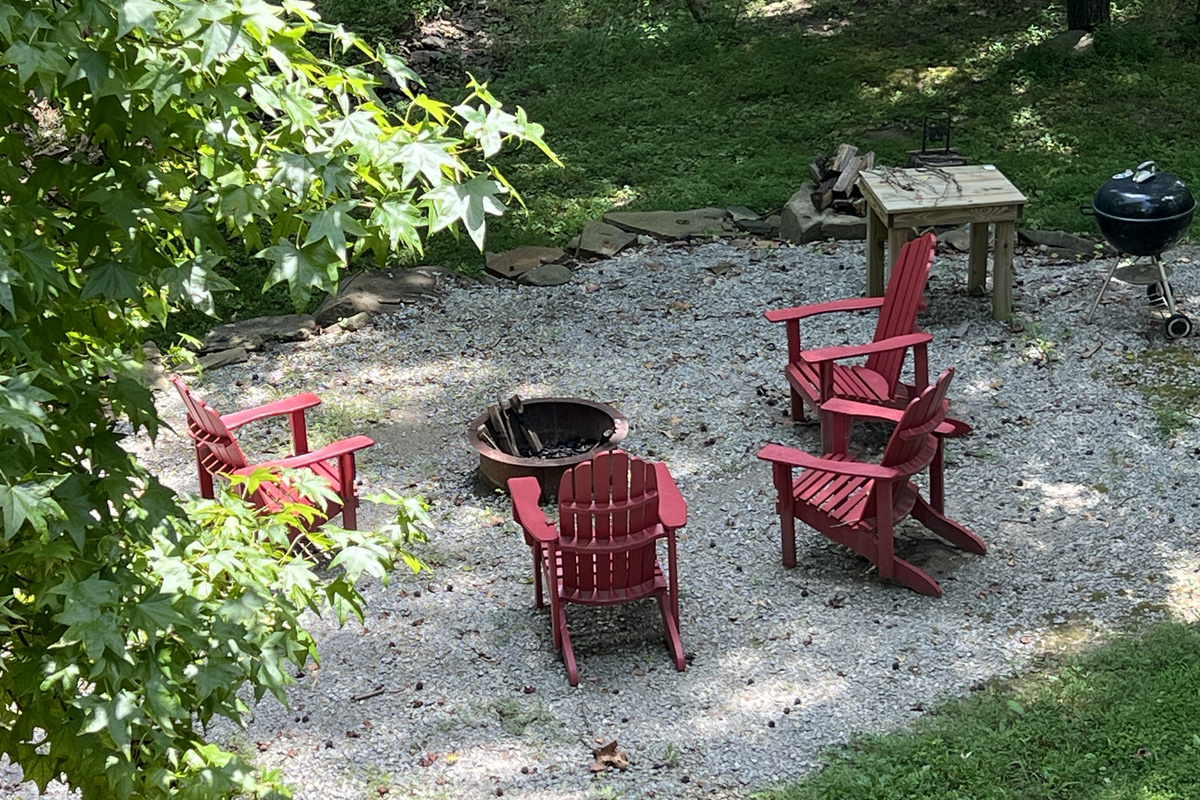 Firepit and grilling area with comfortable Adirondack chairs