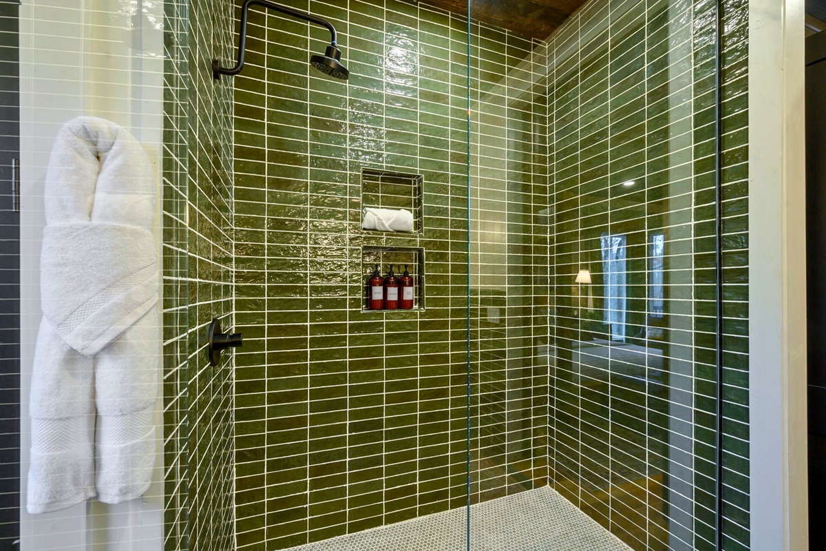This tiled shower blends unique green hues with clean lines, creating a refreshing, modern space.