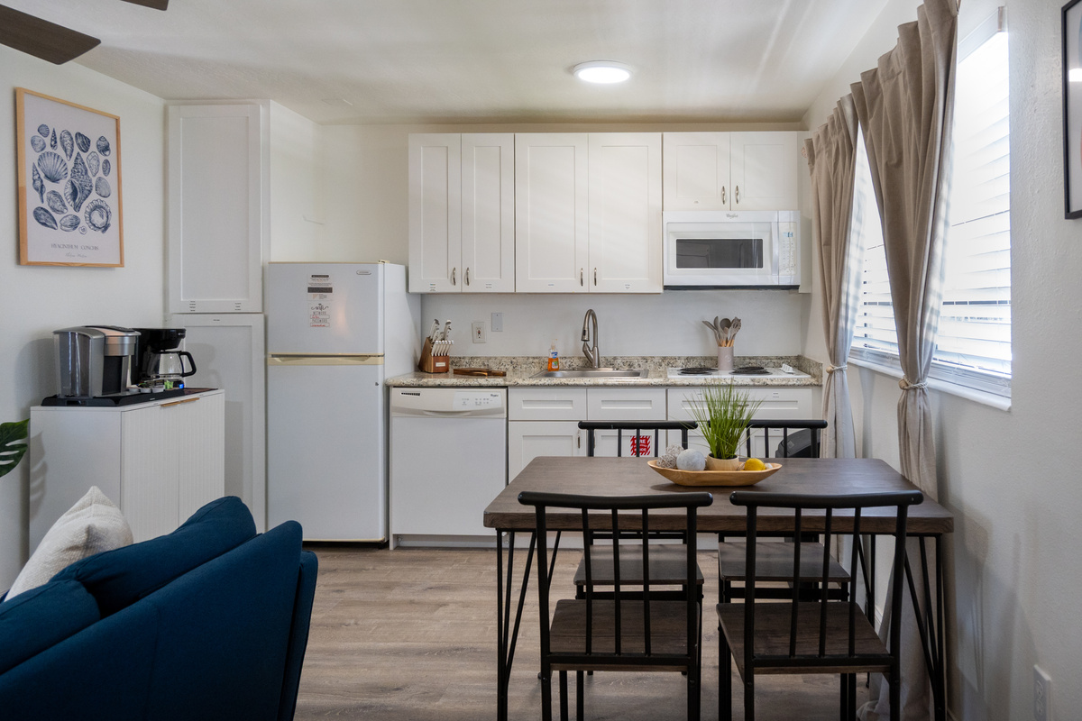 Dining table for four beside the fully stocked kitchen