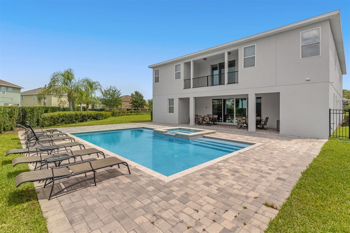 Discover the perfect outdoor retreat at this modern home, featuring a stylish pool and inviting sunbathing chairs. Surrounded by a vibrant landscape, it’s an ideal spot for relaxation and enjoying sunny days in luxury.