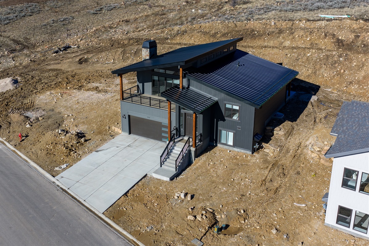 Aerial view showcasing the home’s elevated setting and expansive open landscape.