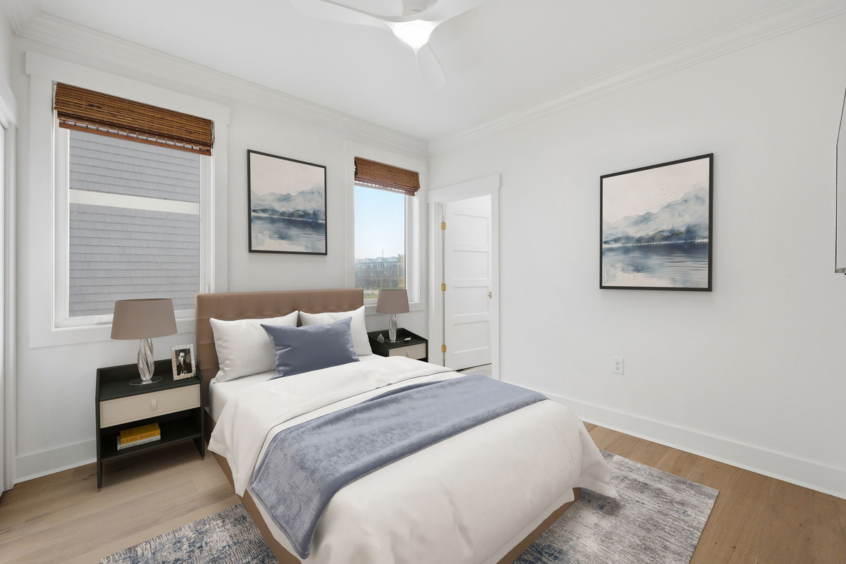 1st floor queen bedroom with neutral coastal d&eacute;cor, framed artwork, and soft natural light from dual windows