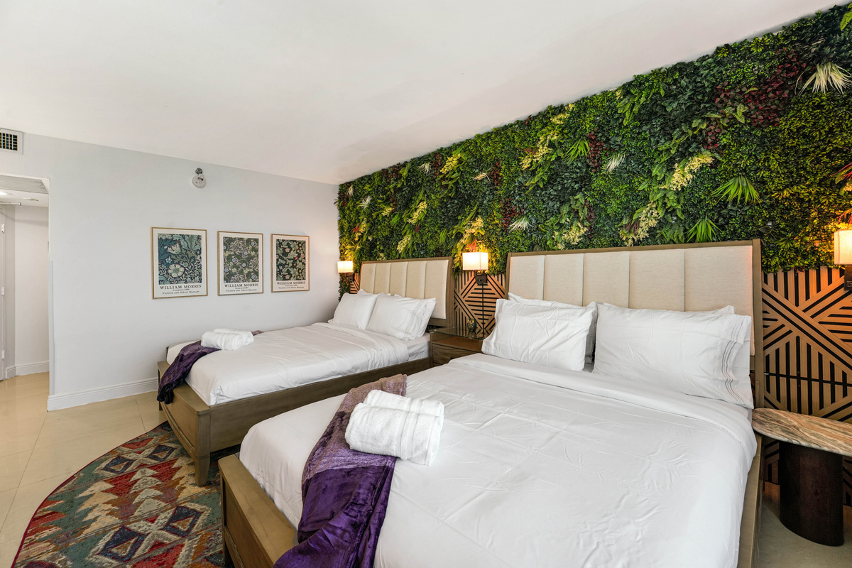 Plush comforters, cozy throws and framed artwork give the sleeping area a calm, boutique-hotel feel.