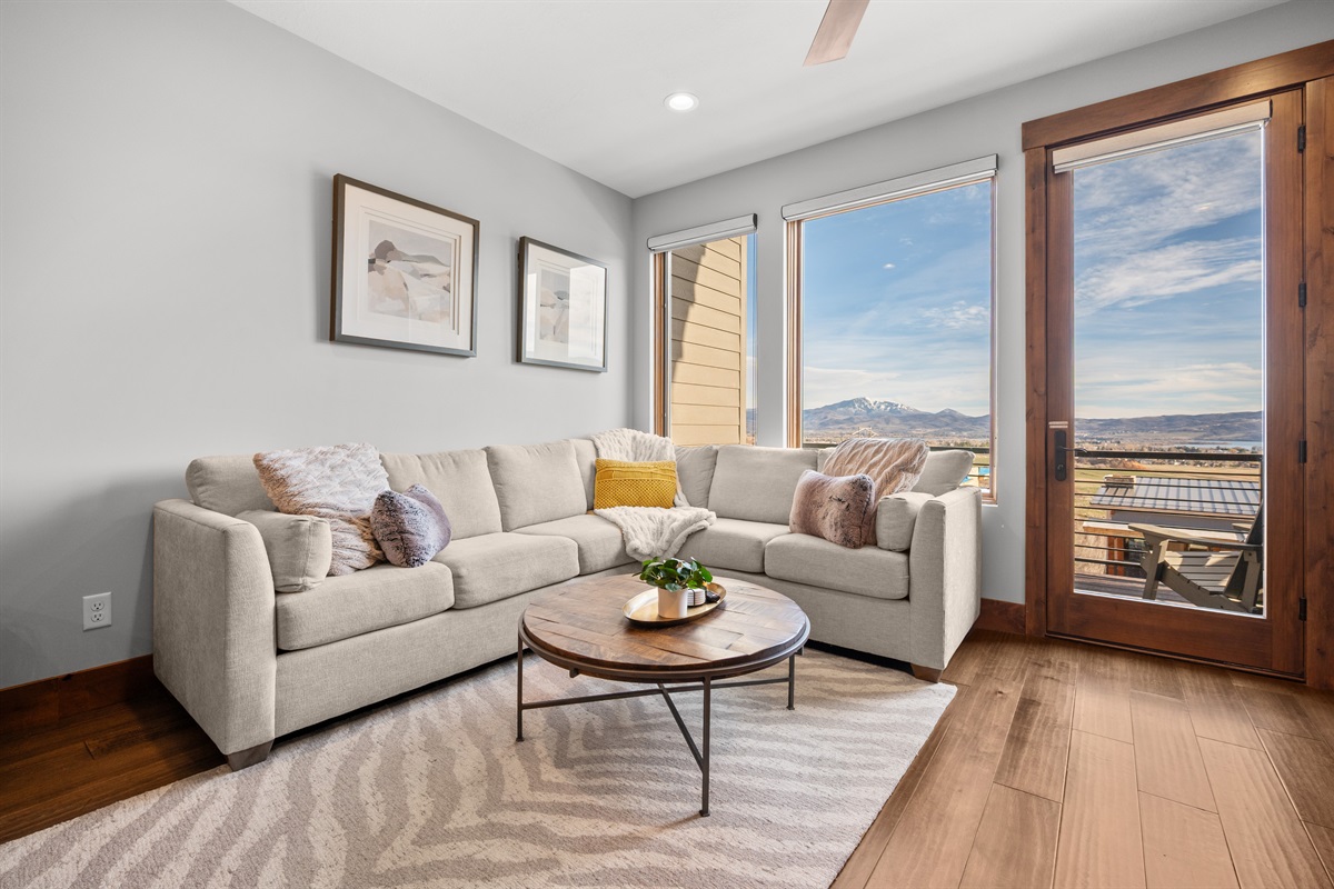 Comfortable living room with large windows and access to private deck