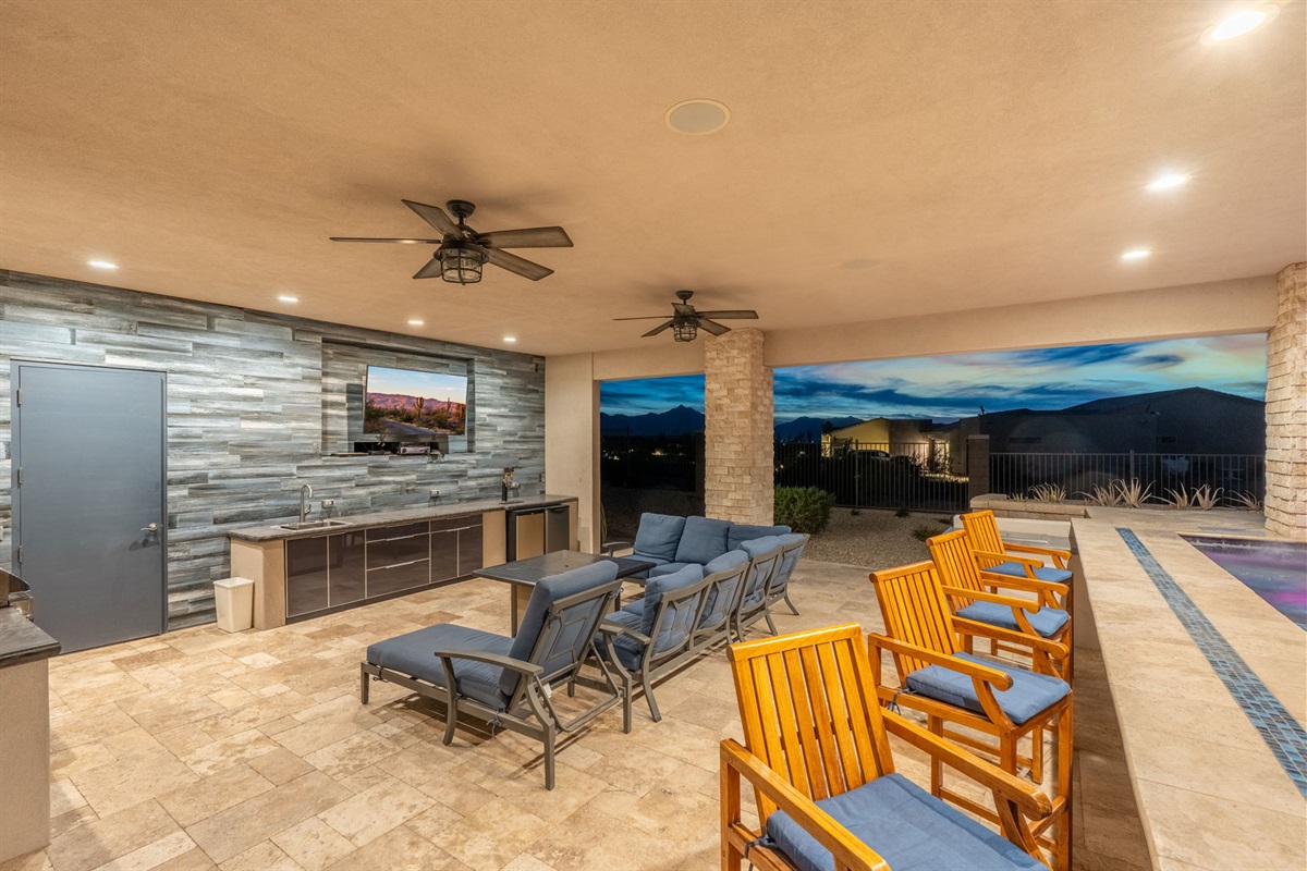 Large covered patio lounge with TV and mountain views designed for group gatherings and game-day evenings
