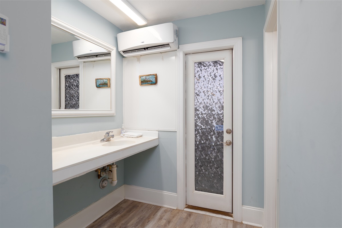 Clean vanity space with mirror and easy access to in-room climate control