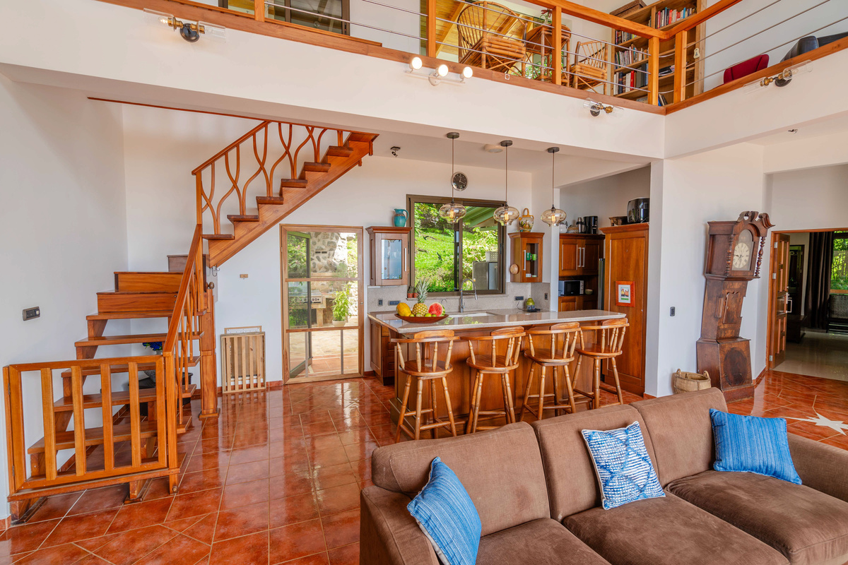 Open-concept living room with soaring ceilings, warm wood accents, and dining area