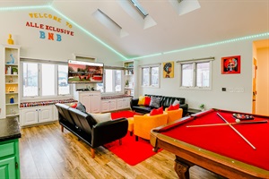 A sophisticated open space featuring a sleek pool table set against a rich red carpet, combining luxury with leisure for the ultimate gaming experience.