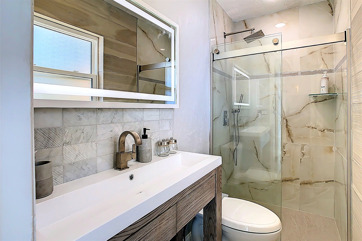 Modern bathroom featuring glass shower enclosure and contemporary fixtures