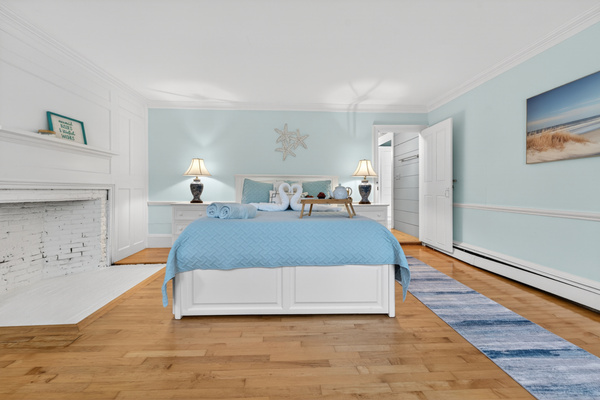 Primary bedroom with a decorative fireplace, and a peaceful atmosphere for restful nights.