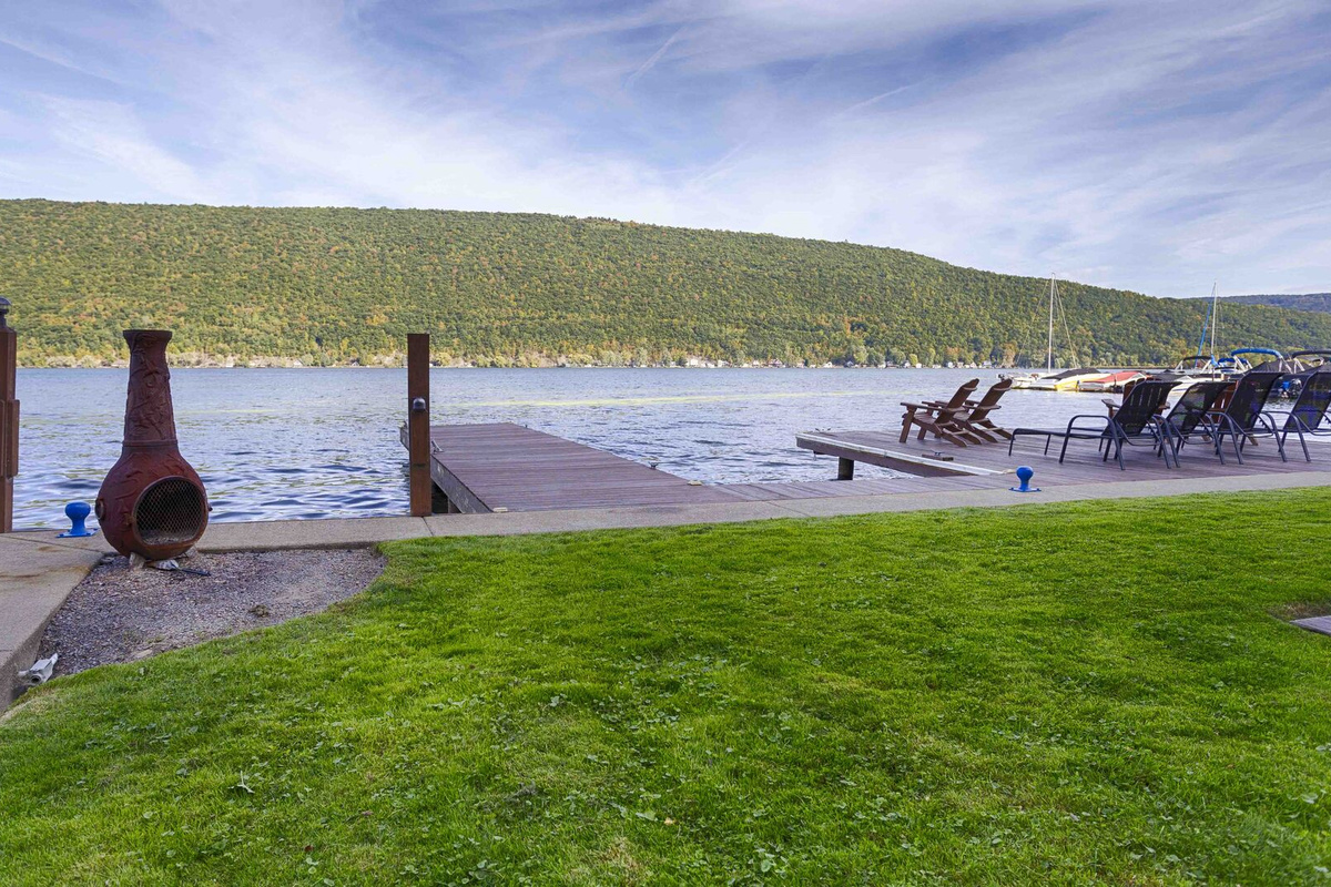 Nestled at the edge of a serene lake, this charming dock features a row of inviting, comfortable chairs, perfect for relaxing and enjoying the peaceful surroundings. The chairs, crafted from weather-resistant materials, are designed for comfort with 