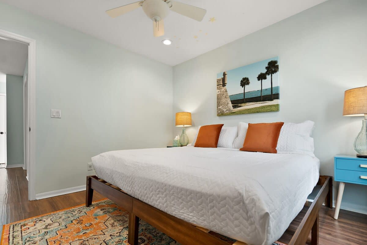 A king bed with warm accents and windows on two sides. Whichever bedroom you end up in there is a ceiling fan turning overhead and plenty of room to put your things down properly for the week ahead of you.