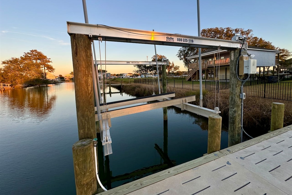 Private backyard dock with boat lift and fillet table, fenced-in backyard, fire pit with Adirondack chairs, hammocks, propane grill, picnic table, outdoor shower, expansive waterfront back deck, neighborhood boat ramp and dock