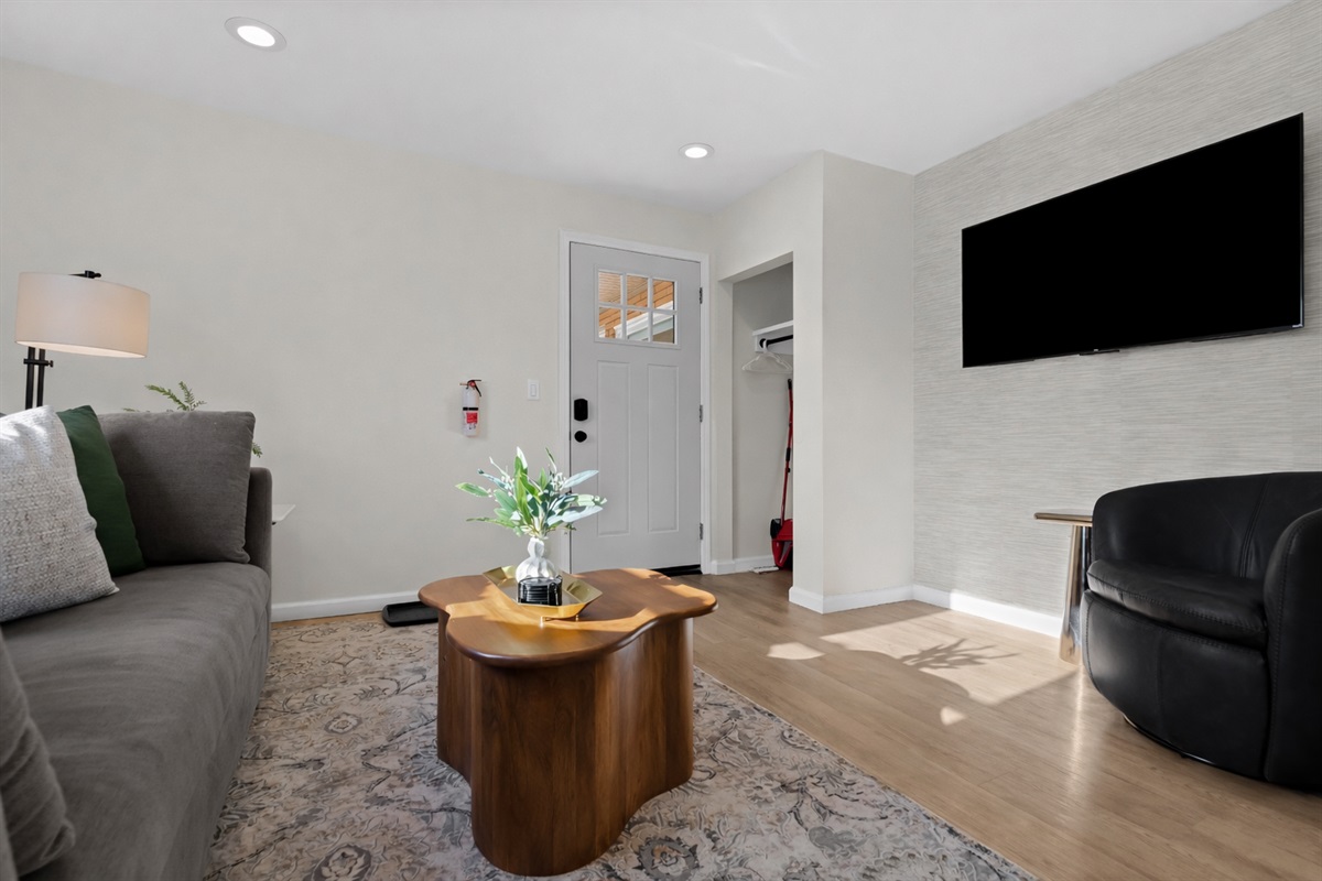 Bright living area with smart TV, modern décor, and comfortable seating—designed for relaxing, streaming your favorites, or enjoying time together.
