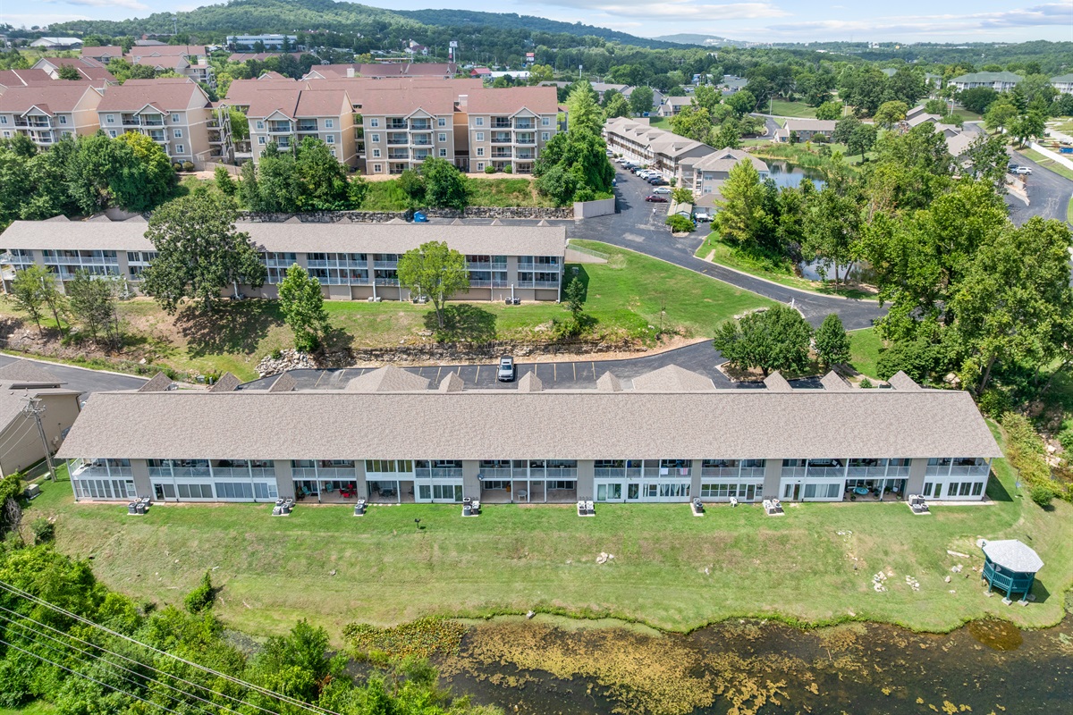 Aerial context shows the condo’s peaceful brookside setting near Branson attractions, lakes, and dining.