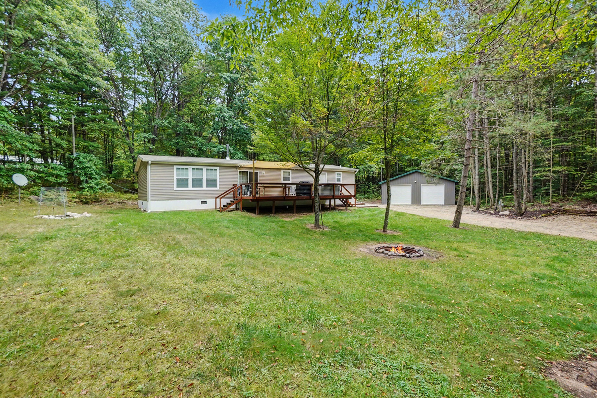 Front view of property with firepit. Hot tub and gas grill on deck.