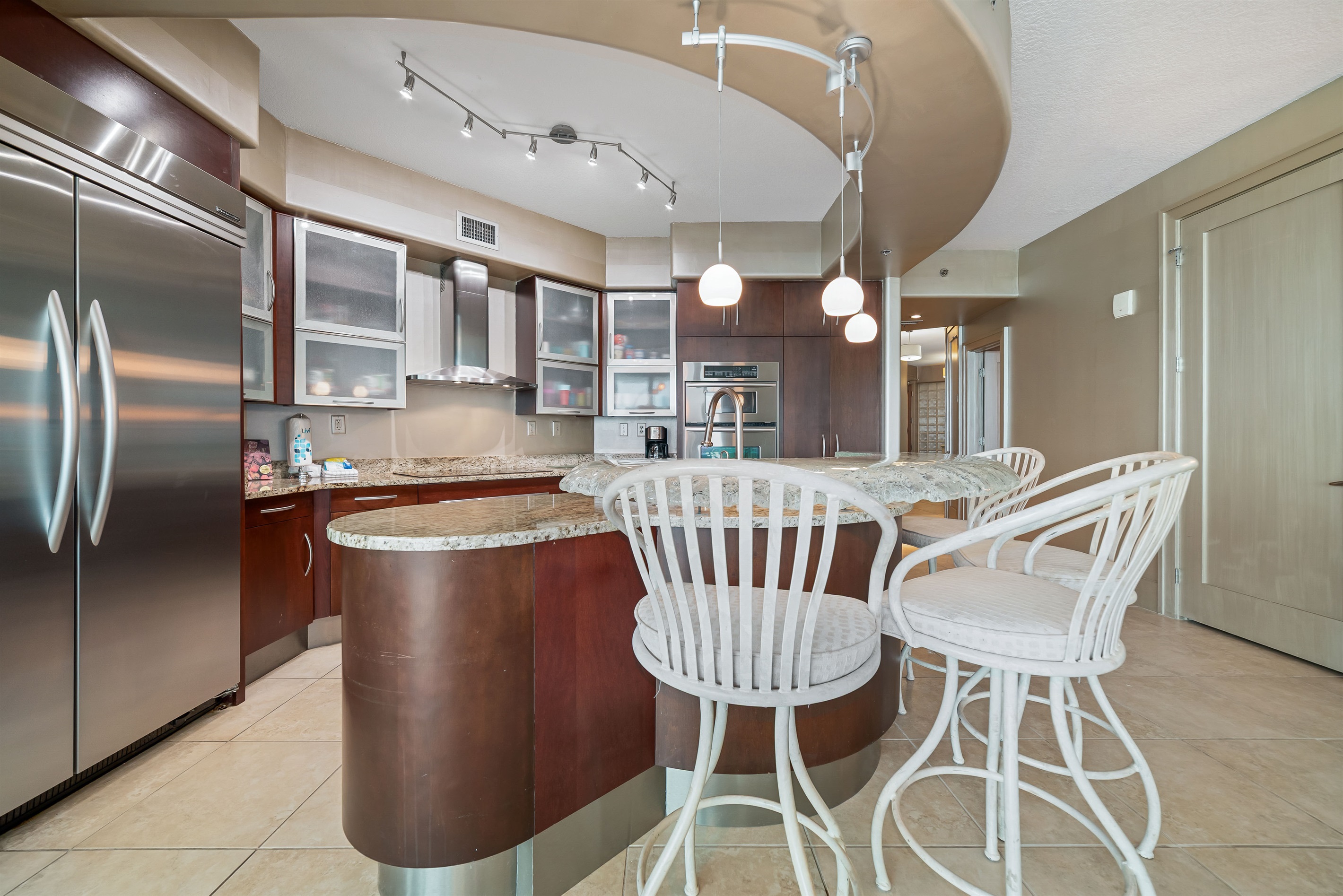 Gourmet kitchen with stainless steel appliances, granite countertops, and island seating. Open floor plan seamlessly connects to the living and dining areas.