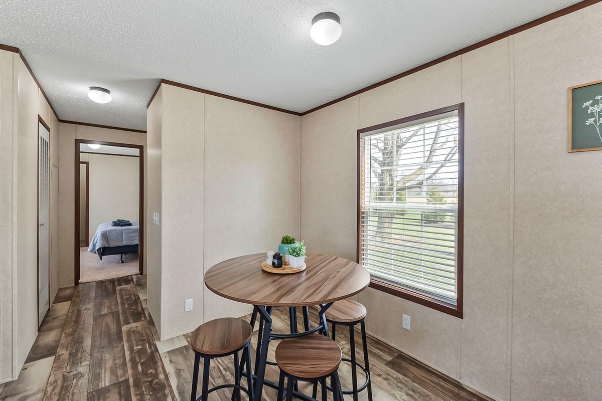 Cozy dining nook with a round table and seating for four, perfectly positioned by the window for natural light and relaxed meals.