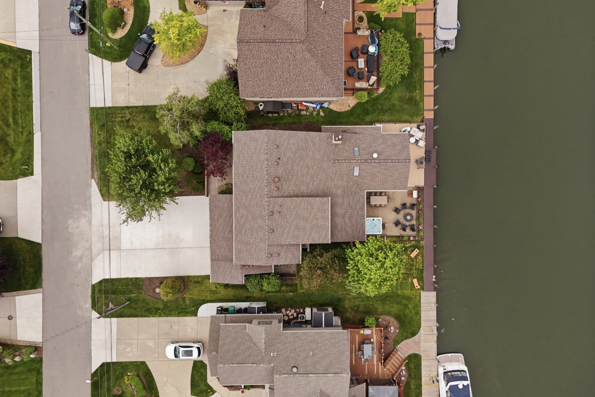 Aerial top-down view of a waterfront home with a private dock and canal access. Clean, well-maintained property offering direct water frontage in a quiet, scenic lake community.