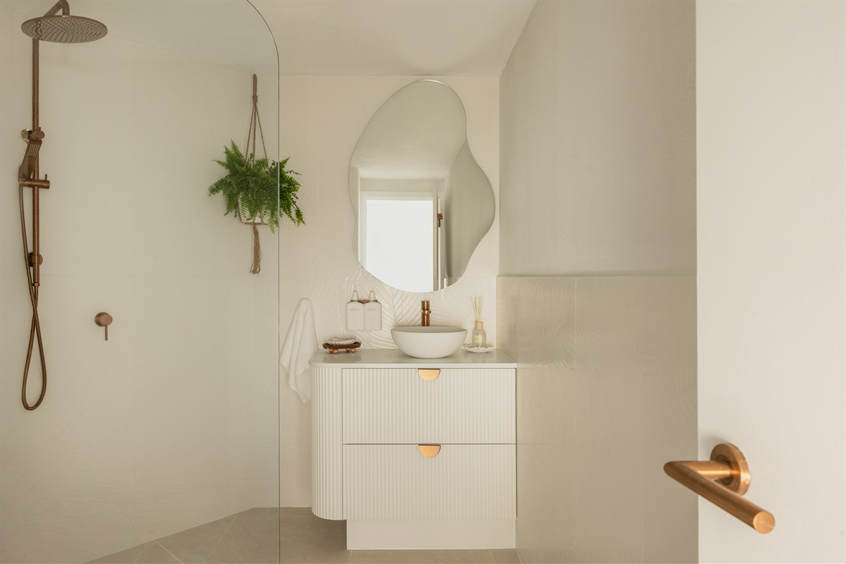 Newly renovated bathroom with chic brushed-copper fixtures, rainfall shower and premium toiletries included.