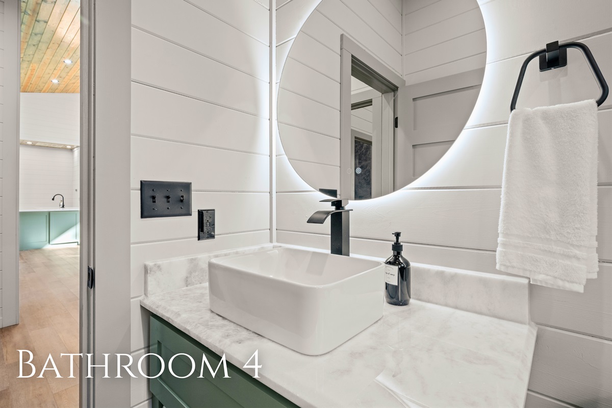 This bathroom features bright lighting, fresh design, and plenty of counter space to keep things simple and comfortable.