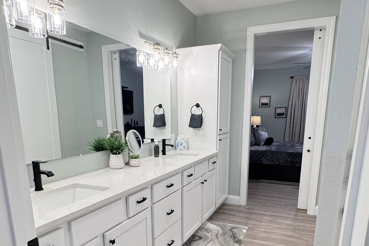 Primary Bathroom en-suite has double sinks, lots of cabinets, towels, toiletries, and a large closet with separate walk-in shower and toilet room.