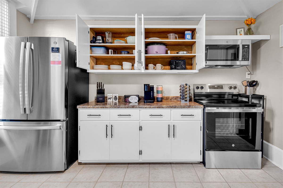 Fully stocked lower-level kitchen with fridge, freezer w/ice-maker, and electric stove/range