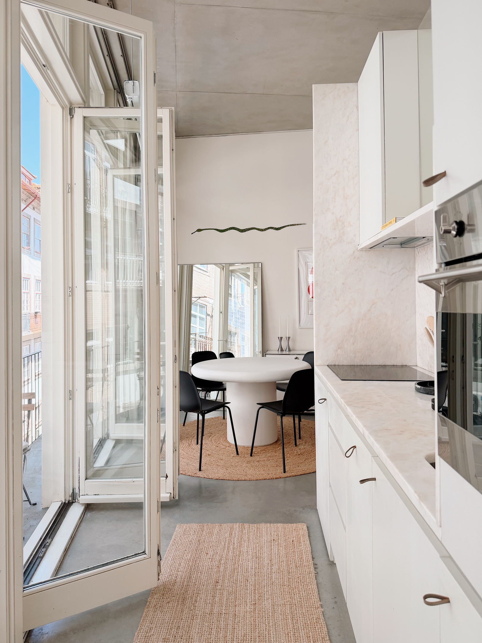 Kitchen and dining area with balcony doors open.