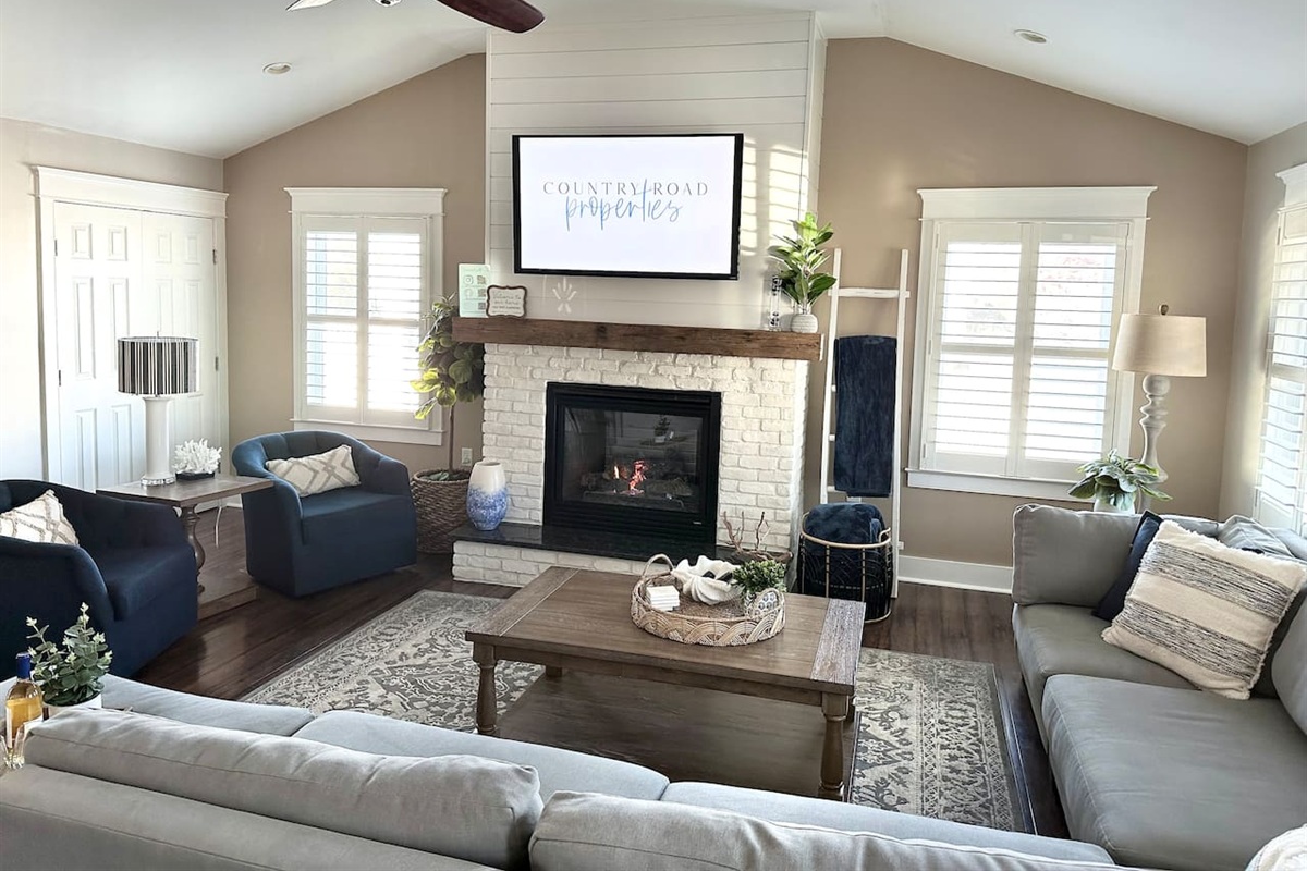 Settle into this airy space with vaulted ceilings and a white brick fireplace. With a large sectional and navy armchairs, it’s a comfortable spot to stream movies or relax after a day at the shore.