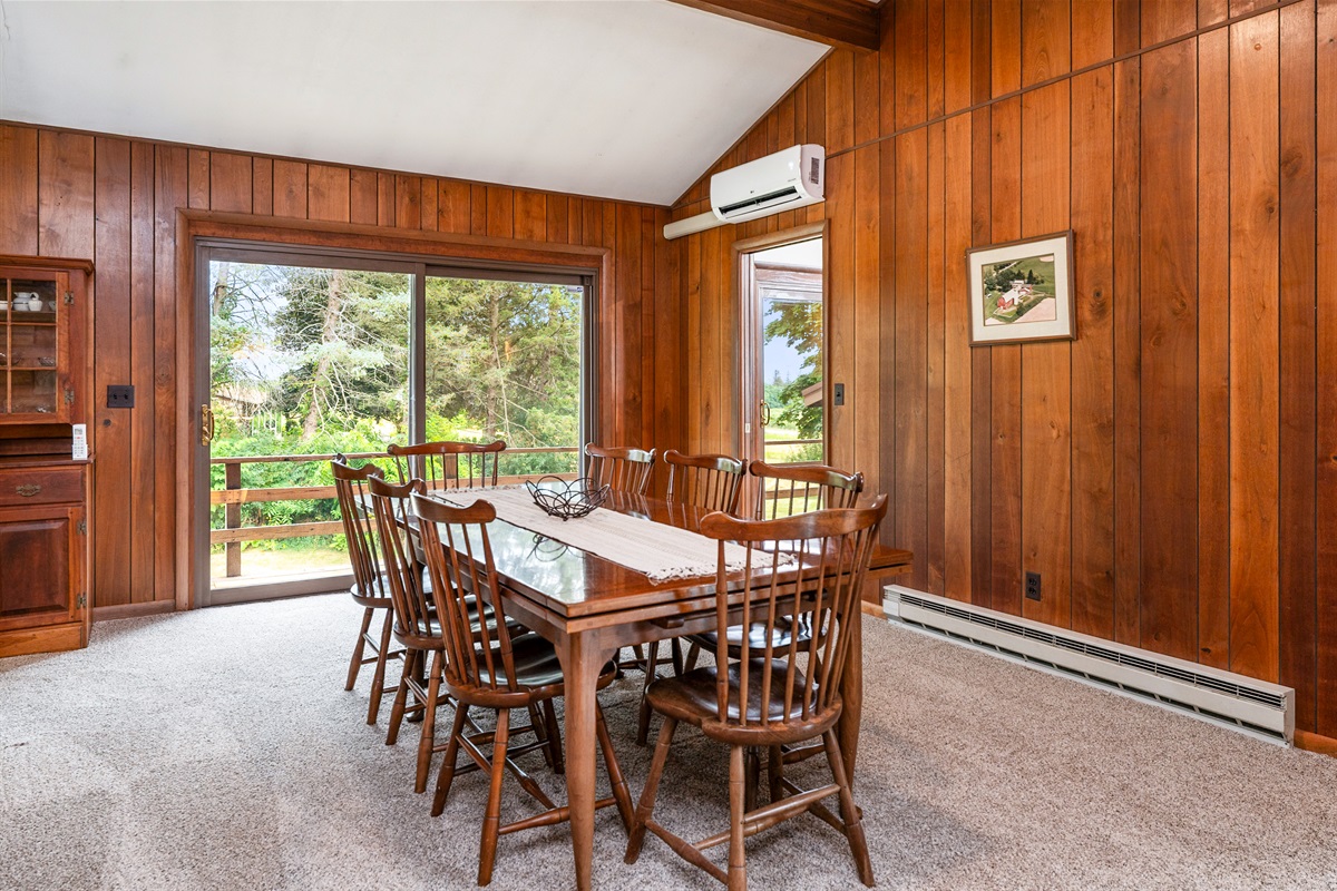Gather around the spacious dining table, surrounded by rich wood tones and bright natural light for memorable meals with family and friends.