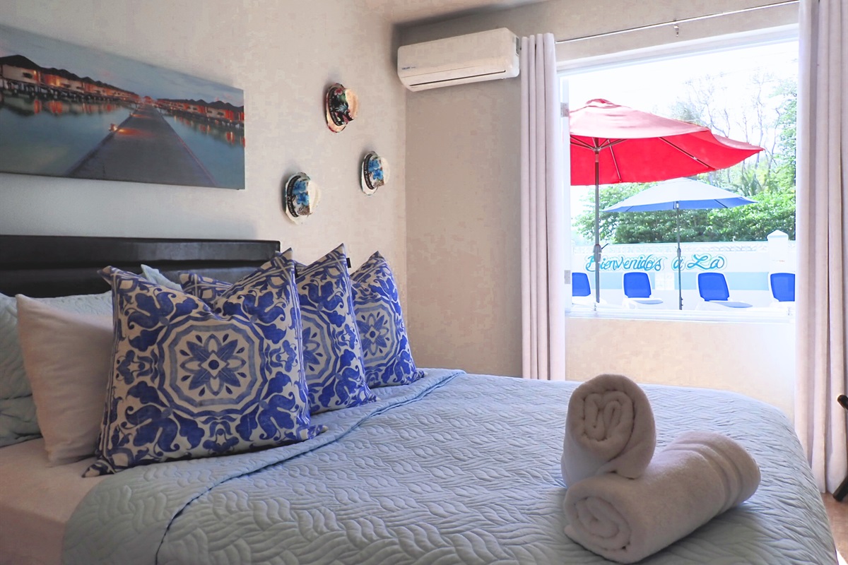 Bedroom Retreat: Bright, stylish room with vibrant decor and lovely views of the outdoor patio!