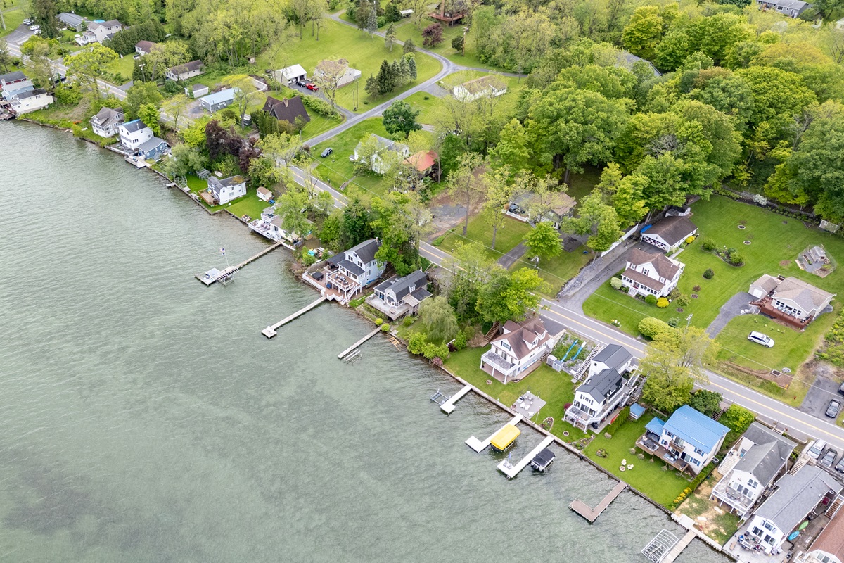 Aerial shot showcasing expansive lakefront entertaining space, hot tub, and private dock for the ultimate getaway 🎯🌊🍹