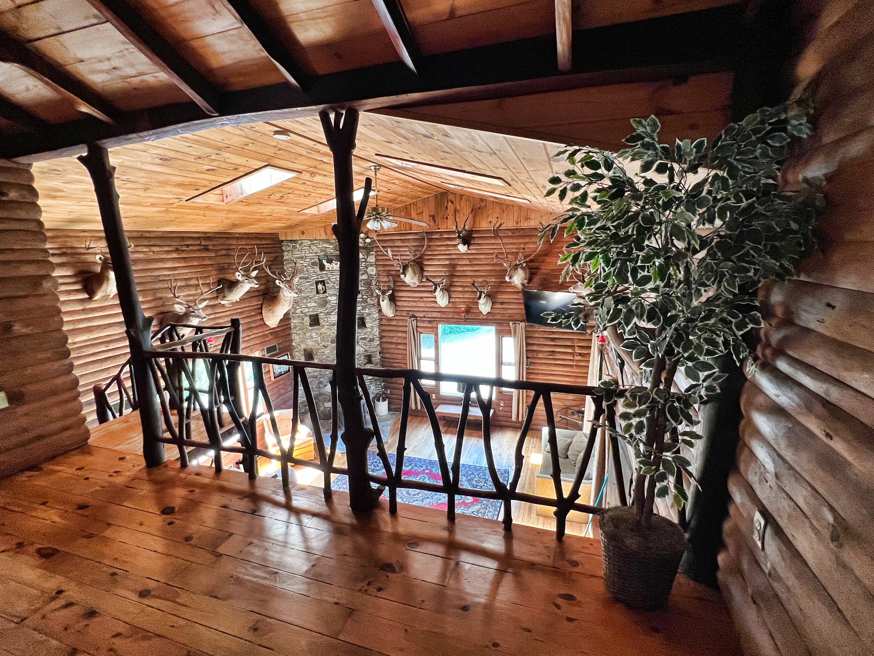 View of living room and trophy room from 2nd floor landing. Full bathroom located to the left.