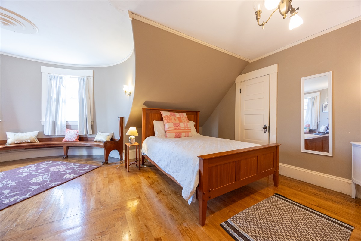 Fourth bedroom with a queen bed and a cozy spot to sit and unwind.