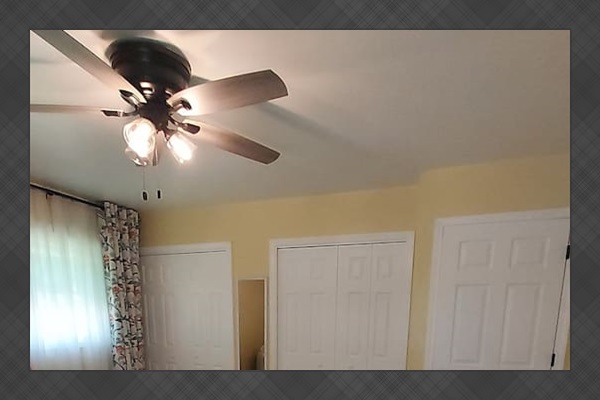 This sunny master suite feels spacious and uplifting, with soft yellow walls and floral curtains that brighten the room. Two roomy his-and-her closets offer generous storage, and natural light creates a peaceful, cheerful vibe all day.