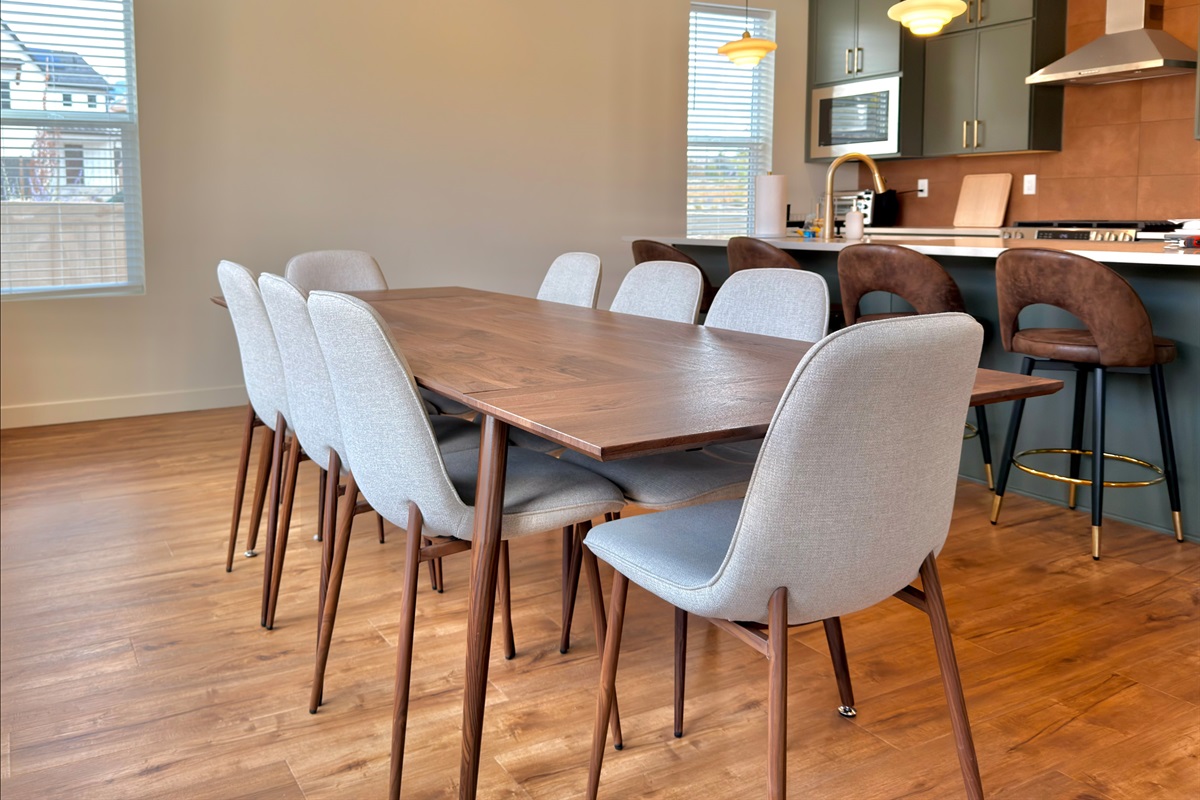 Elegant dining table for eight with soft lighting and an open layout, ideal for group dinners or gatherings.