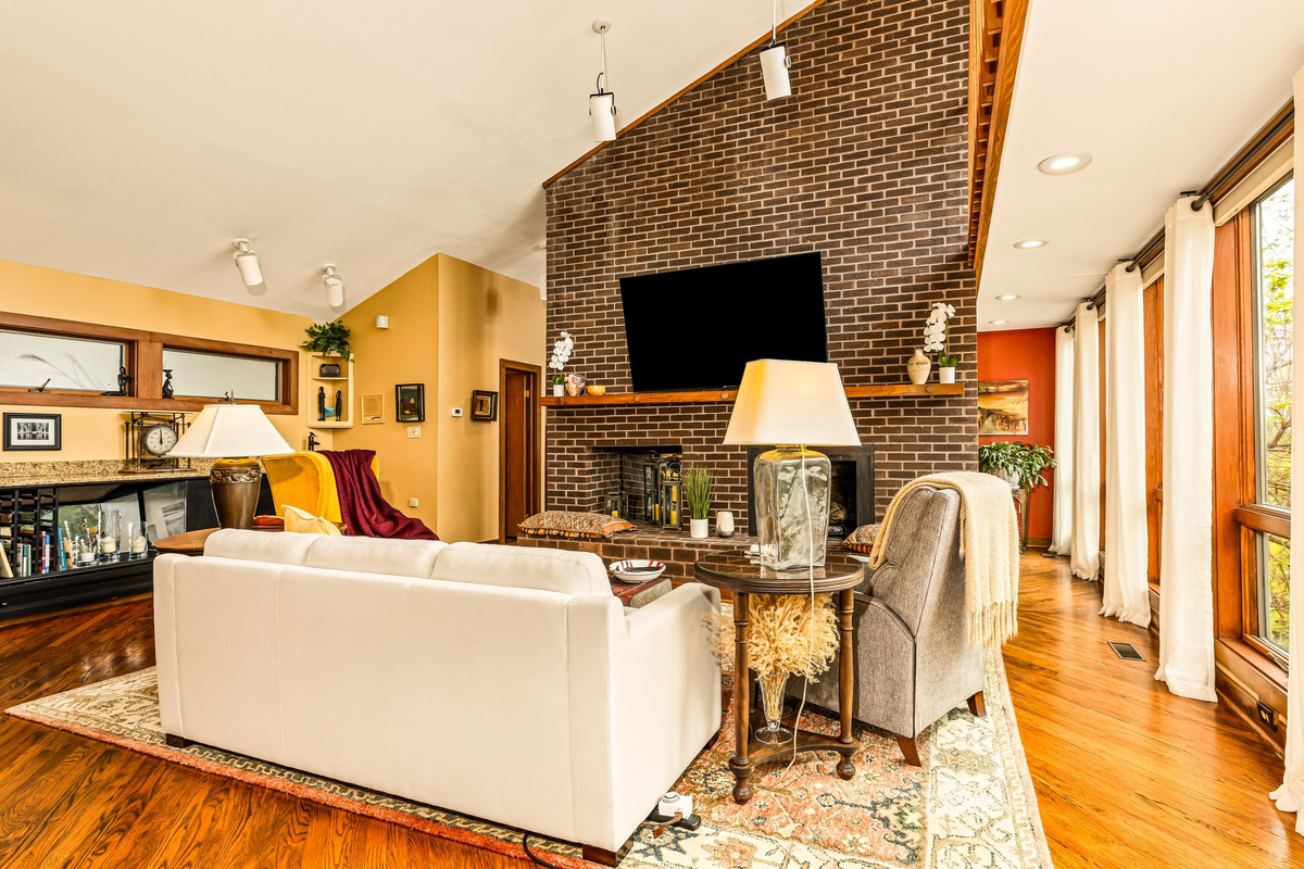 Soaring windows frame gorgeous sunrises and storms rolling by! Comfy seating, people you like - all together in the perfect place to hang out together in front of the fireplace! 75" Roku TV for watching shows or background music.