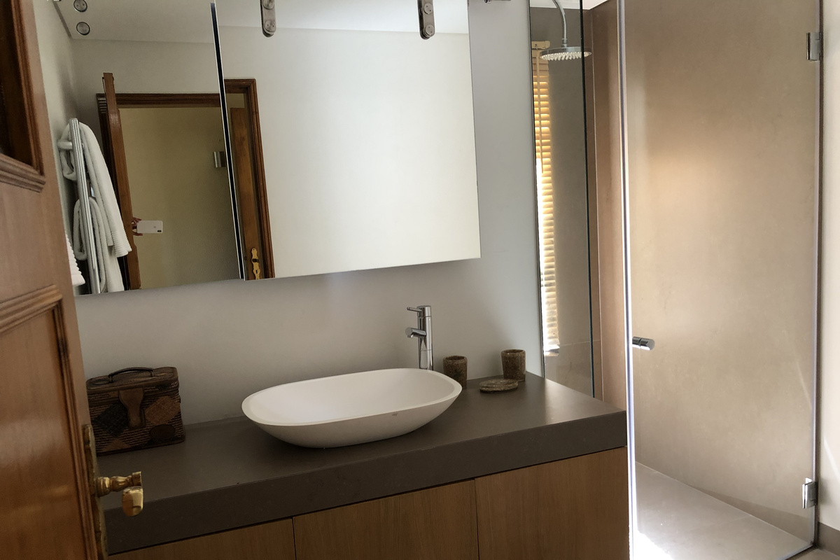 Casa do Prado Bathroom Style
All bedrooms have private bathrooms. This one includes a walk-in shower and a large countertop sink. The mirror slides to reveal an extra window, bringing in natural light and fresh air.