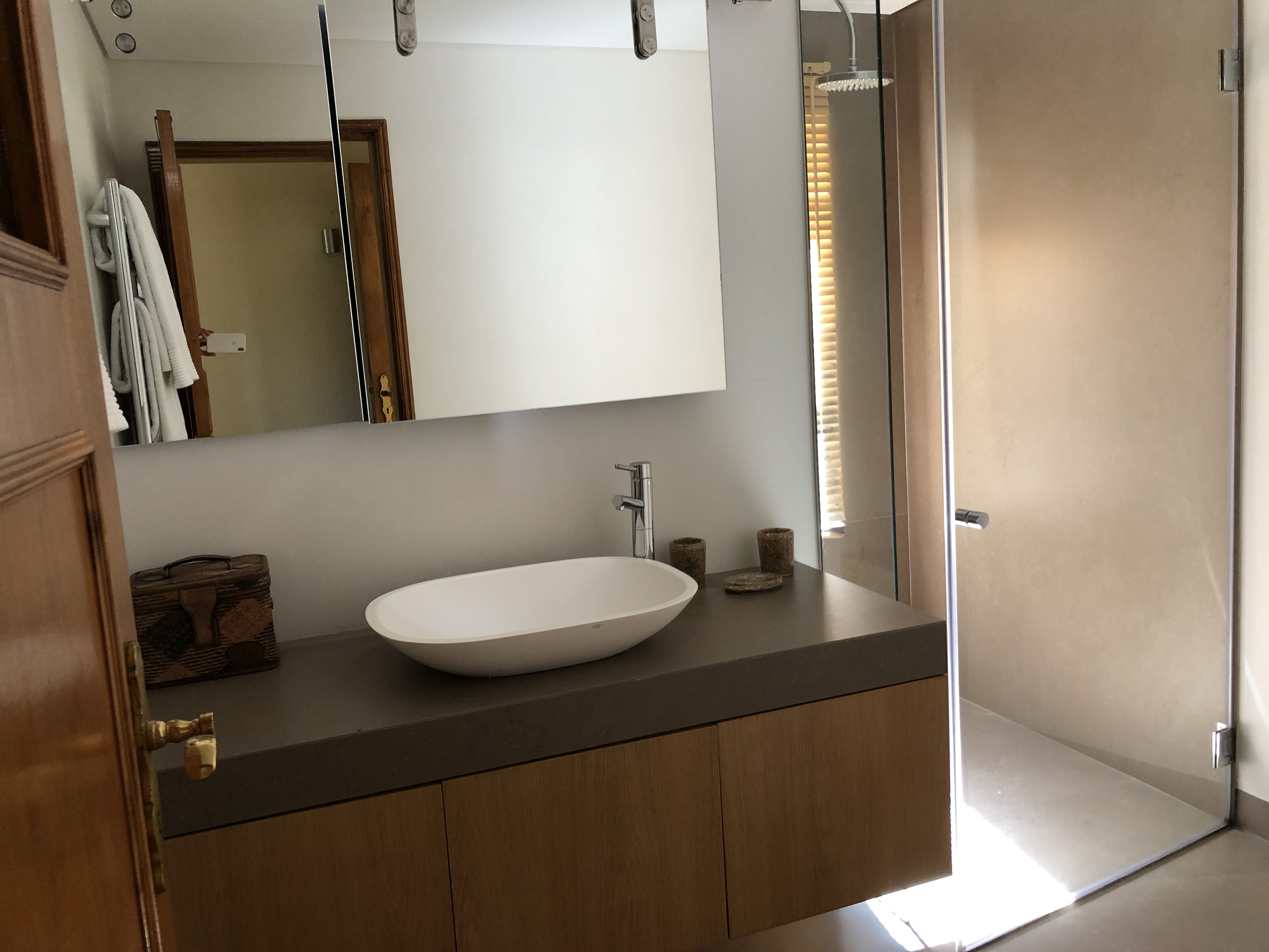 Casa do Prado Bathroom Style
All bedrooms have private bathrooms. This one includes a walk-in shower and a large countertop sink. The mirror slides to reveal an extra window, bringing in natural light and fresh air.